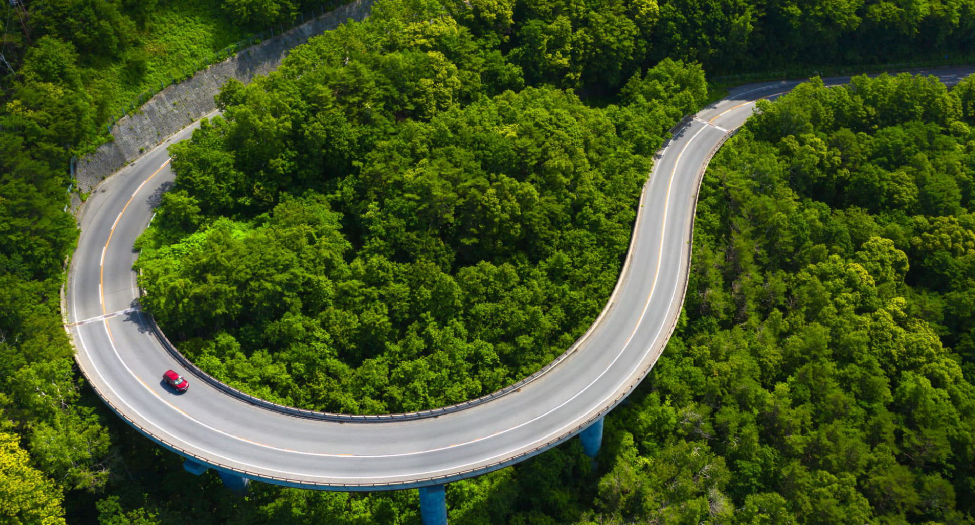 自然の中に設けられた曲線のループ橋のイメージ。